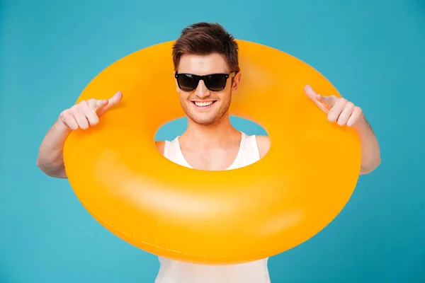 Chico en gafas de sol sosteniendo anillo inflable arjalá su cuello — Foto de Stock