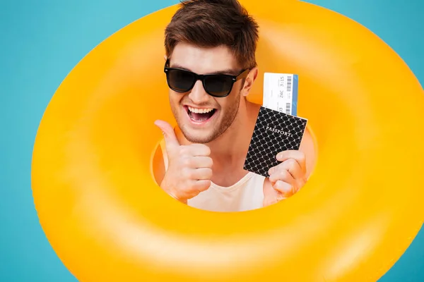 Feliz hombre excitado en gafas de sol mirando a través del anillo inflable — Foto de Stock