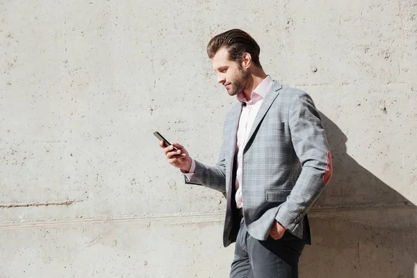Портрет счастливого человека в куртке с мобильным телефоном — стоковое фото