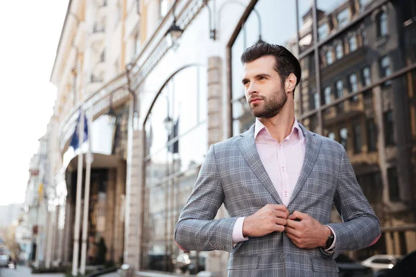 Portrait of a young handsome man buttoning his jacket — Stock Photo, Image