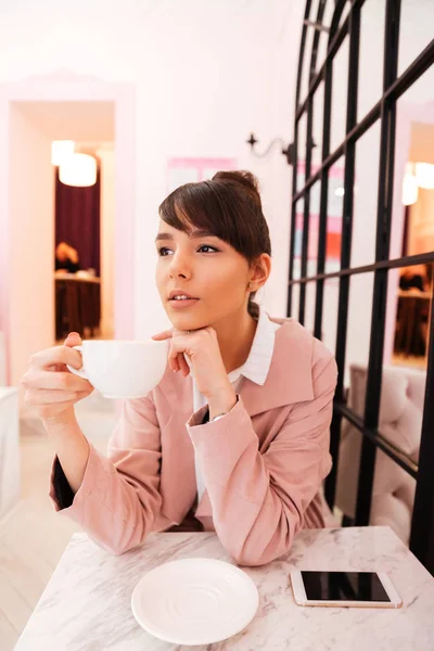 Retrato de una joven atractiva sosteniendo una taza de café — Foto de Stock