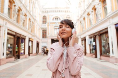 Mutlu kız bir şehir sokak üzerinde müzik dinleme keyfi