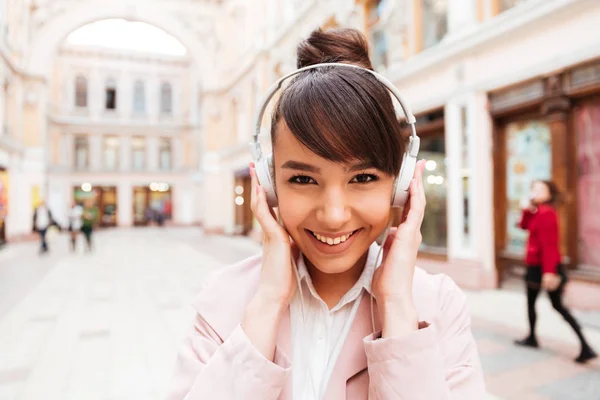 Portrait d'une fille mignonne souriante écoutant de la musique avec des écouteurs — Photo
