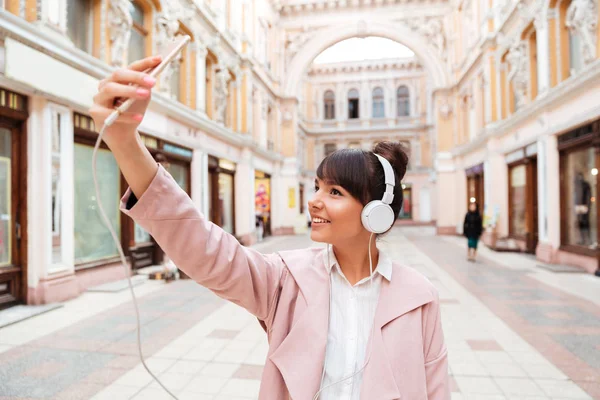 Ευτυχισμένος κορίτσι χαμογελαστό ακουστικά κάνοντας selfie φωτογραφία — Φωτογραφία Αρχείου