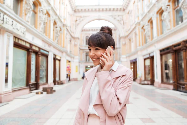 Дівчина розмовляє на мобільному телефоні, стоячи на вулиці — стокове фото