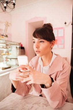 cep telefonu tutan düşünceli genç kadın