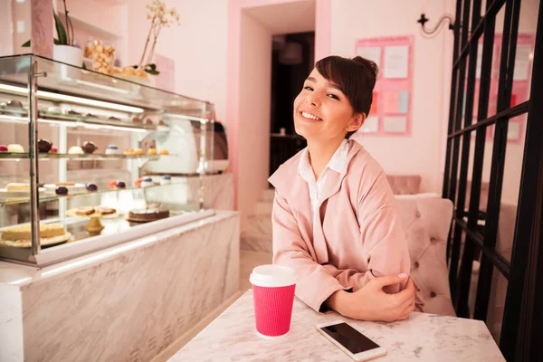 Lachende mooie vrouw zitten in de cafetaria — Stockfoto