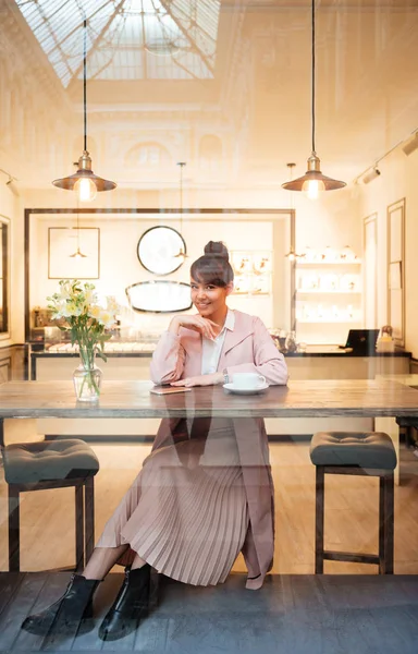 Retrato de una joven sentada en el moderno café — Foto de Stock