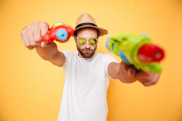 Joven serio sosteniendo pistolas de agua de juguete . — Foto de Stock