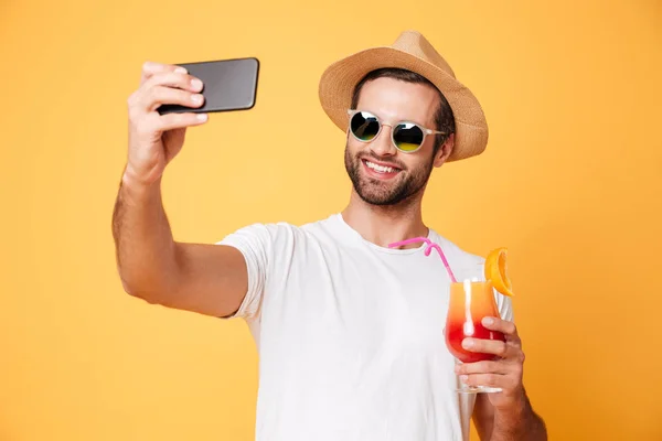 Sonriente joven hacer selfie por teléfono celebración de cóctel . — Foto de Stock