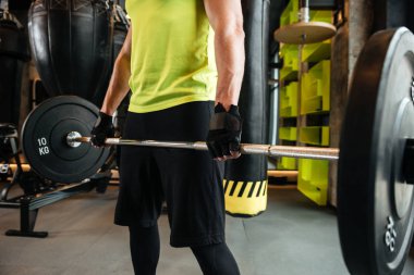 Barbell ile genç bir kaslı adam Resim kırpılmış