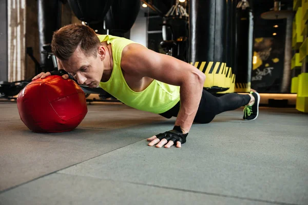 Unga allvarliga sportsman göra sport övningar i gymmet — Stockfoto