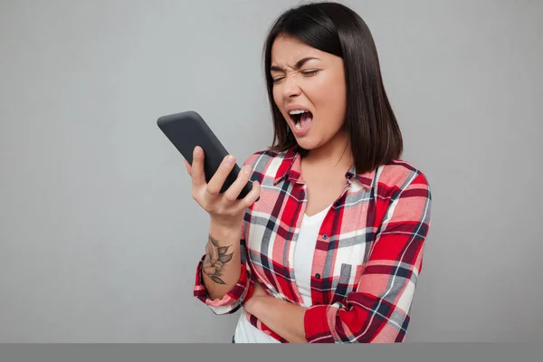 Boze jonge Aziatische vrouw geïsoleerd met behulp van de telefoon. — Stockfoto