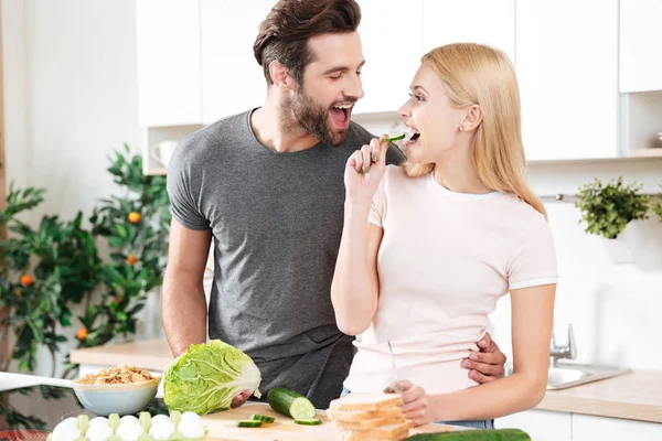 Смішна молода закохана пара стоїть на кухні і готує — стокове фото