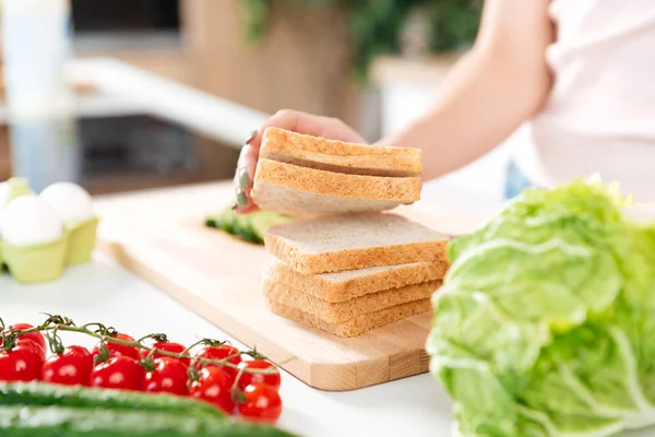 Nő így szendvicsek, zöldségekkel, egy vágódeszka — Stock Fotó