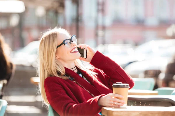 コーヒーを飲みながら電話で話して幸せな若い白人女性. — ストック写真