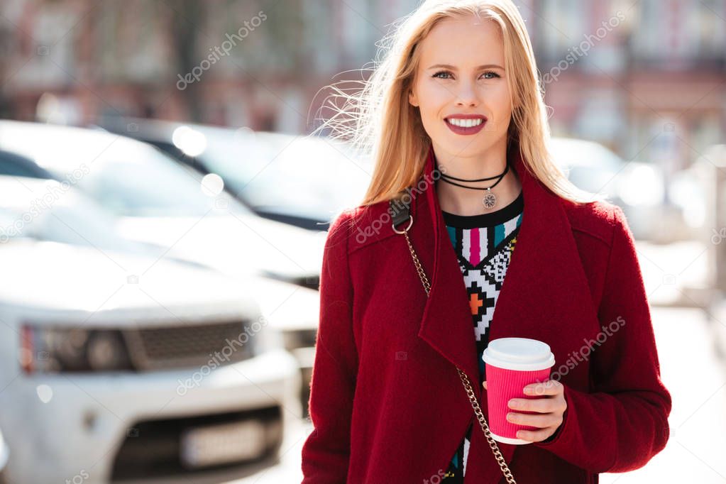 Cheerful fashion young blonde woman walking outdoors