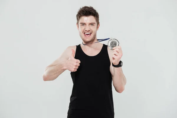 Jovem desportista feliz segurando medalha — Fotografia de Stock