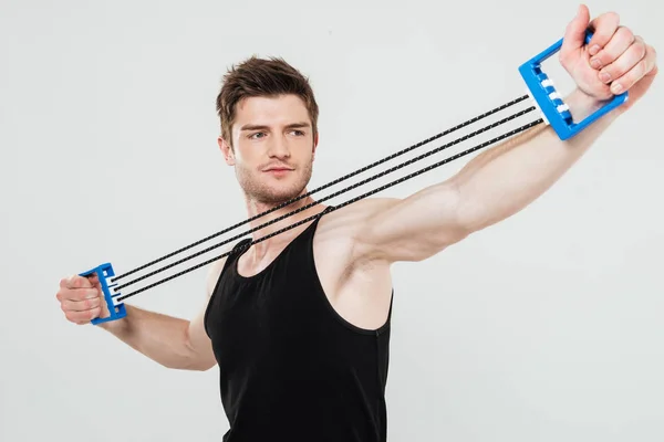 Jovem desportista concentrado faz exercícios desportivos — Fotografia de Stock