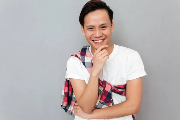회색 배경 위에 웃는 젊은 아시아 남자 — 스톡 사진