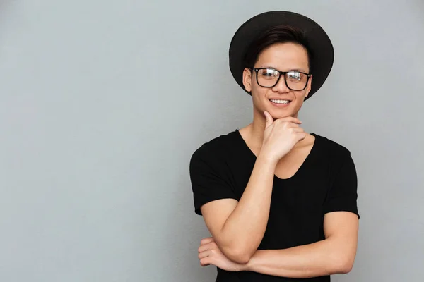Glücklicher junger asiatischer Mann steht isoliert über grauer Wand — Stockfoto