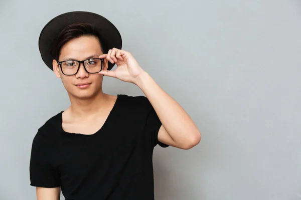 Happy young asian man standing isolated over grey wall — Stock Photo, Image