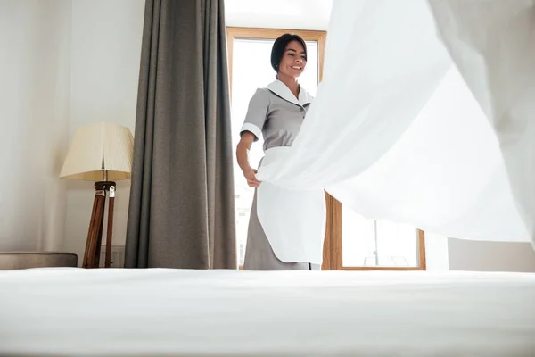 Hotel maid changing bed sheet — Stock Photo, Image