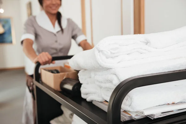 Skadrowana młoda pokojówka przynosząc czyste ręczniki — Zdjęcie stockowe