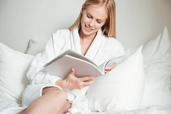 Mujer joven acostada en la cama en la habitación del hotel —  Fotos de Stock