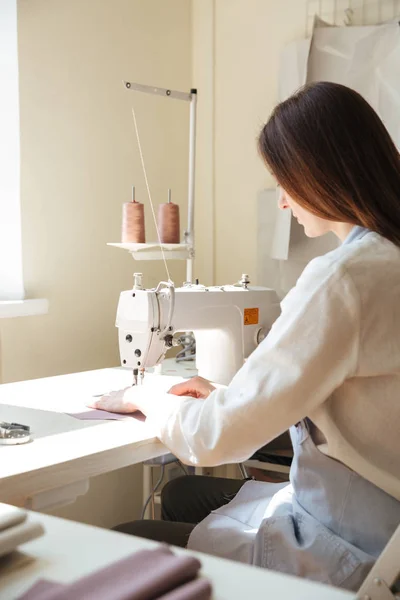 Back view of seamstress working with sewing machine — Stock Photo, Image