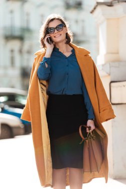 Açık havada telefonla konuşurken yürüyen kadın