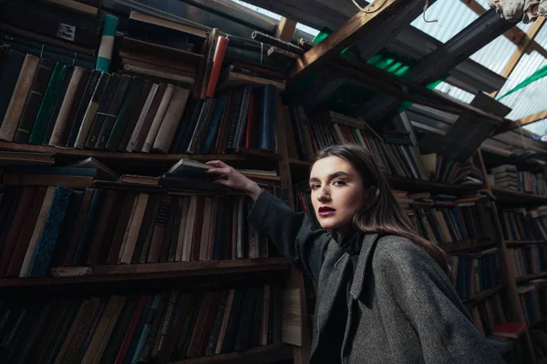 Retrato de uma mulher na moda em casaco levando livro — Fotografia de Stock