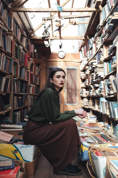 Ruhige Frau sitzt auf Büchern — Stockfoto
