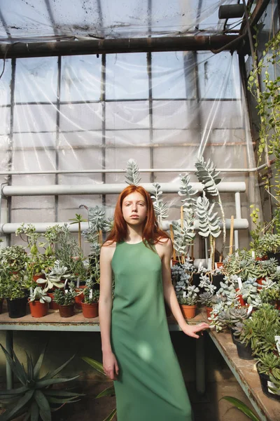 Girl standing in a glass house and looking at camera — Stock Photo, Image