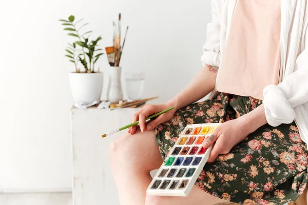 Cropped picture of young caucasian lady painter