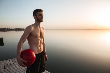 Plaj topu ile ayakta ciddi genç sporcu.