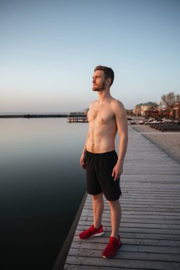 Plajda durup konsantre genç sporcu