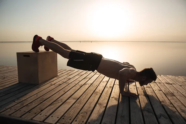 Egészséges fiatalember csinál push-up with a speciális berendezések — Stock Fotó