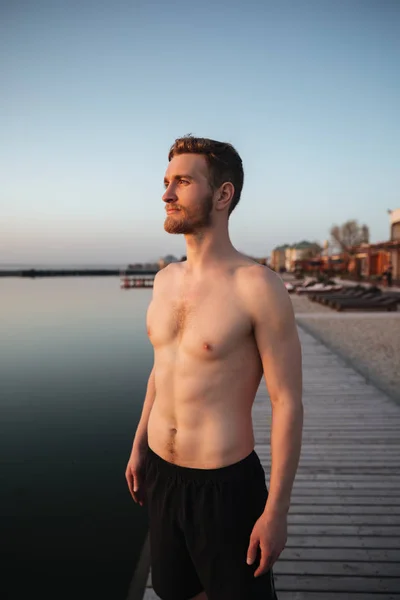 Συμπυκνωμένο νεαρός αθλητής που στέκεται στην παραλία — Φωτογραφία Αρχείου
