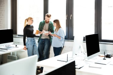 Genç arkadaşları birbirleriyle konuşurken Office konsantre