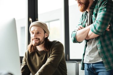 Yakışıklı erkek meslektaşları ofiste bilgisayar kullanarak