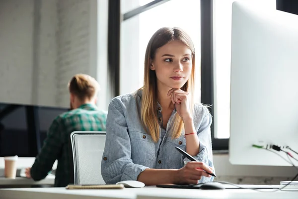 Ung kvinna arbete i office med hjälp av dator och ritplatta — Stockfoto