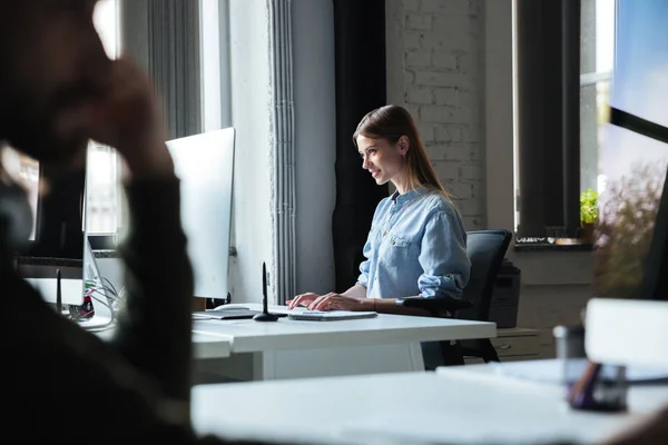 En kvinne jobber på kontoret med datamaskin. Ser til side . – stockfoto