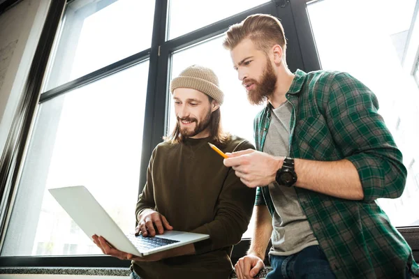 Ung koncentrerad män kollegor i office med laptop — Stockfoto