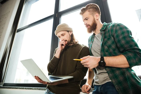 Ung koncentrerad män kollegor i office med laptop — Stockfoto