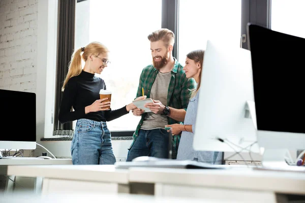 Jeunes collègues concentrés au bureau qui discutent entre eux — Photo