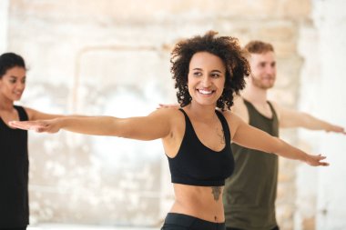 Gülümseyen genç Afrikalı kadın yoga egzersizleri yapıyor