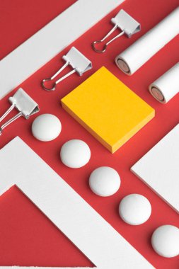 Kırmızı arka plandaki tabloda ofis malzemeleri