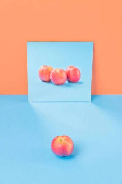 Orange på blå bord isolerade över orange bakgrund — Stockfoto