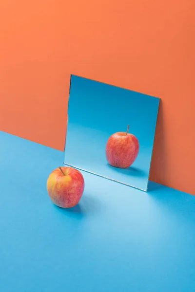 Apple na niebieski tabeli na białym tle pomarańczowy — Zdjęcie stockowe